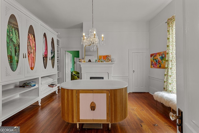walk in closet featuring a chandelier, dark wood-style floors, visible vents, and a fireplace