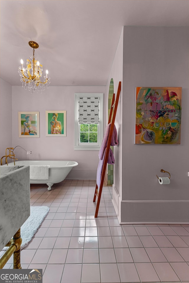 full bathroom with baseboards, tile patterned floors, a freestanding bath, and a notable chandelier