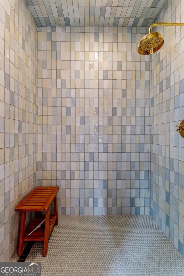 bathroom featuring tile walls, tiled shower, and tile patterned flooring