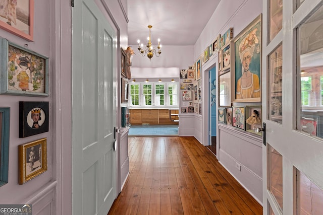 hall featuring hardwood / wood-style flooring and a chandelier