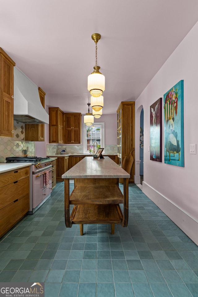 dining room featuring dark tile patterned flooring and arched walkways