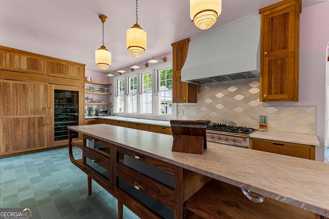 kitchen with brown cabinets, open shelves, hanging light fixtures, premium range hood, and tasteful backsplash