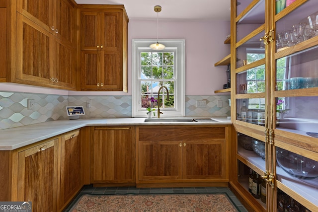 kitchen featuring brown cabinetry, a sink, and light countertops
