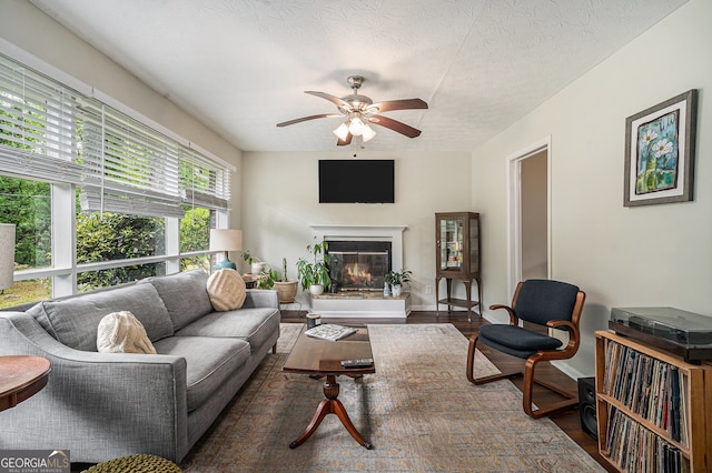2623 Riggs Dr, Atlanta, GA 30344 - living room featuring a ceiling fan, a textured ceiling, a glass covered fireplace, and wood finished floors