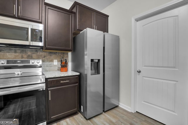 481 Akins Ranch Rd NE, Ludowici, GA 31316 - kitchen with dark brown cabinetry, backsplash, light stone counters, light wood finished floors, and stainless steel appliances