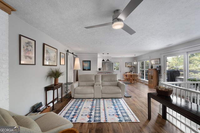 175 Mayo Rd, Covington, GA 30014 - living room featuring a barn door, a textured ceiling, ceiling fan, and wood finished floors