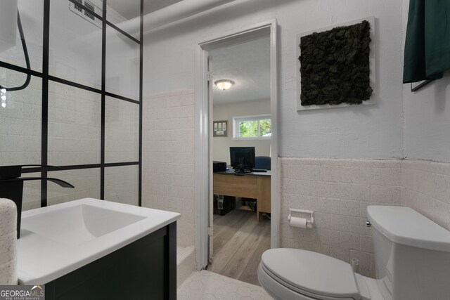 175 Mayo Rd, Covington, GA 30014 - full bath featuring vanity, toilet, a wainscoted wall, tile walls, and wood finished floors
