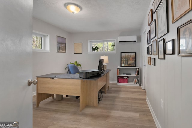 175 Mayo Rd, Covington, GA 30014 - home office featuring an AC wall unit, a textured ceiling, and light wood-style flooring