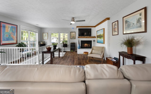175 Mayo Rd, Covington, GA 30014 - living room with a ceiling fan, a textured ceiling, a brick fireplace, and wood finished floors