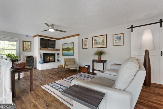 175 Mayo Rd, Covington, GA 30014 - living room featuring a ceiling fan, a barn door, wood finished floors, and a fireplace