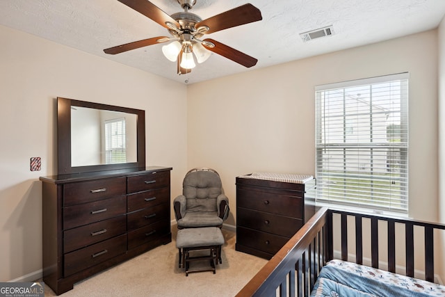 bedroom featuring light colored carpet, baseboards, visible vents, and ceiling fan