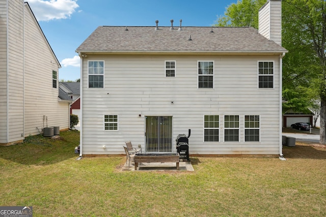 back of house with a chimney, a lawn, a patio area, cooling unit, and a shingled roof