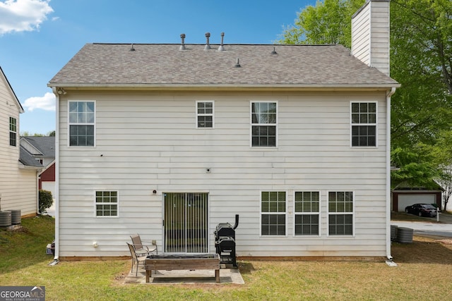 back of property with a yard, a patio, and a chimney