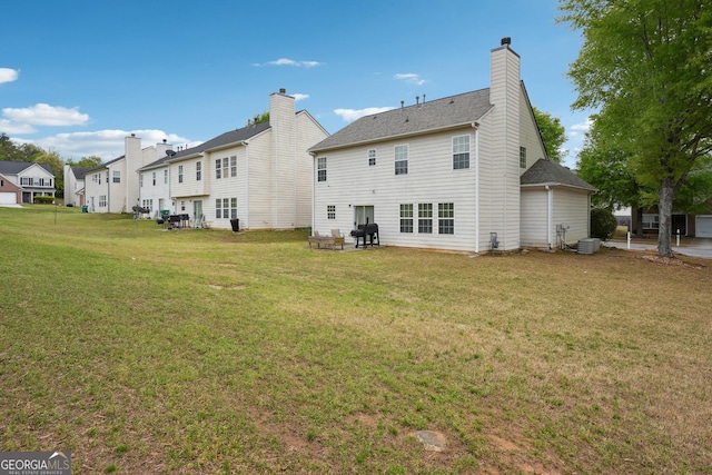 rear view of house featuring a residential view, a shingled roof, a chimney, central air condition unit, and a yard