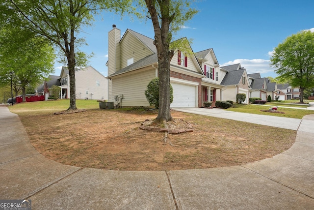 view of side of property with a residential view, a chimney, cooling unit, a lawn, and driveway