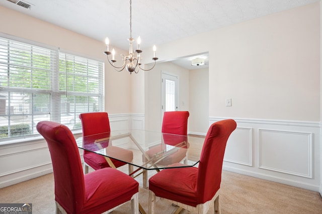 dining space with a chandelier, a wealth of natural light, and a decorative wall