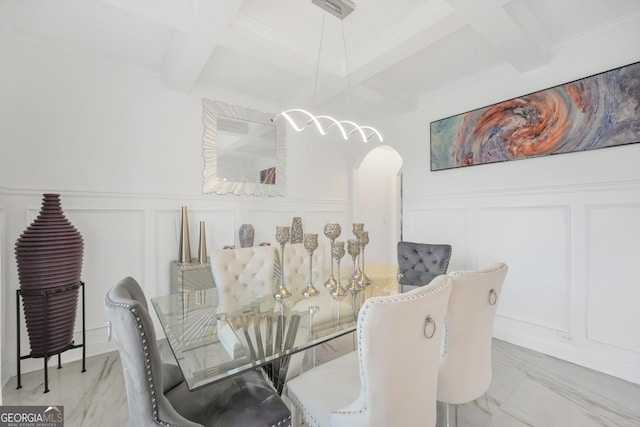 dining area featuring a decorative wall, arched walkways, wainscoting, beamed ceiling, and coffered ceiling