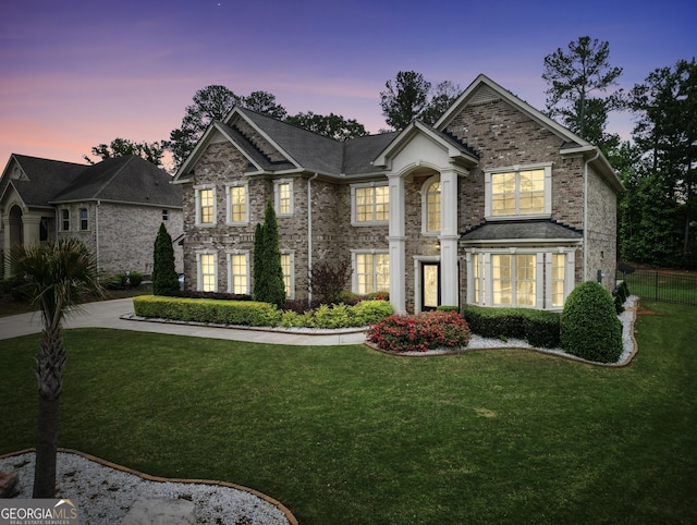 traditional home with brick siding, fence, and a front yard