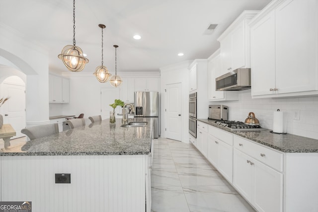 kitchen featuring appliances with stainless steel finishes, arched walkways, marble finish floor, ornamental molding, and recessed lighting