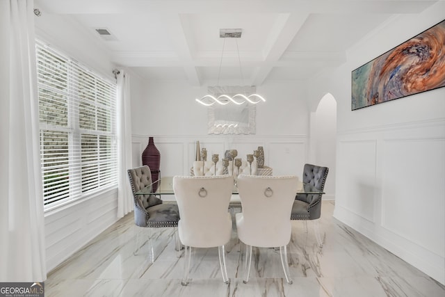 dining space featuring arched walkways, a chandelier, a decorative wall, and a wealth of natural light