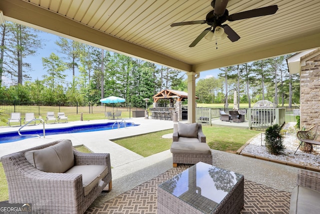 view of patio with a fenced backyard, outdoor dry bar, an outdoor hangout area, and a ceiling fan
