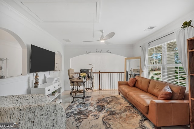 living area with ornamental molding, a ceiling fan, attic access, and visible vents