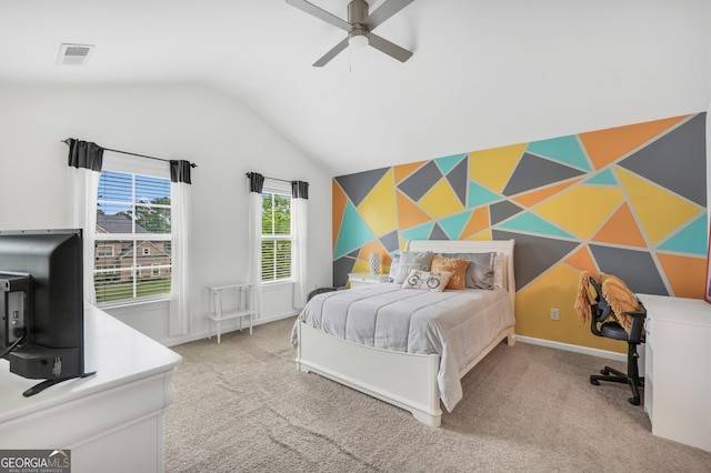 bedroom with a ceiling fan, visible vents, vaulted ceiling, an accent wall, and carpet flooring