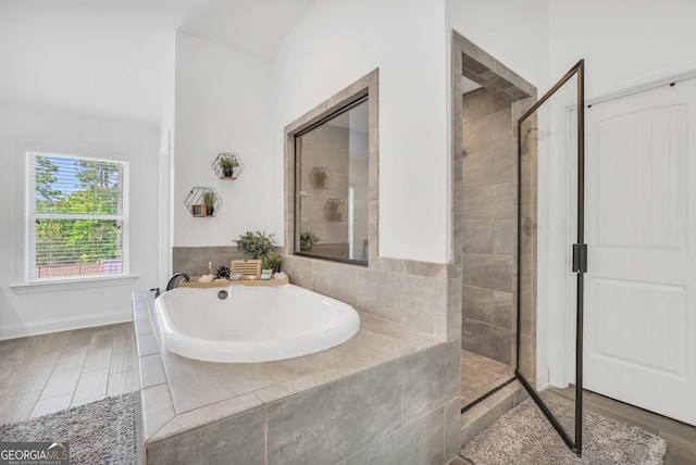 bathroom with a tile shower and a garden tub
