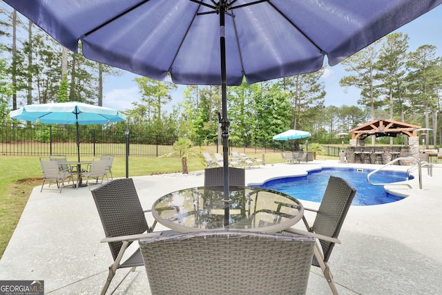 view of swimming pool featuring fence, outdoor dry bar, outdoor dining area, and a patio area
