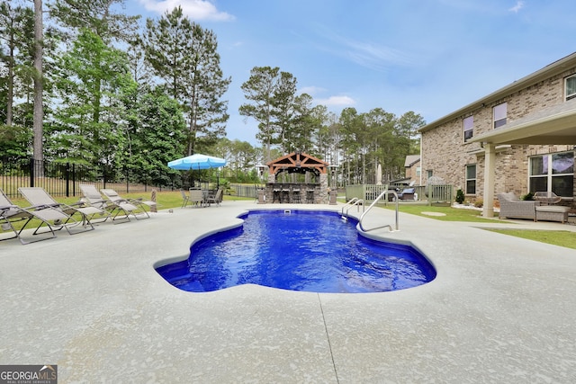 view of swimming pool with fence, a gazebo, outdoor lounge area, and a patio area