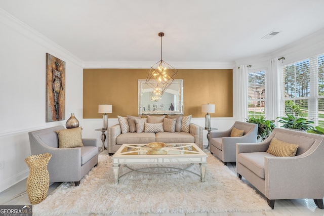 living area featuring crown molding, a wainscoted wall, an inviting chandelier, and visible vents
