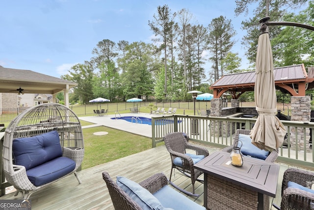 deck with a gazebo, a fenced backyard, a lawn, and a fenced in pool