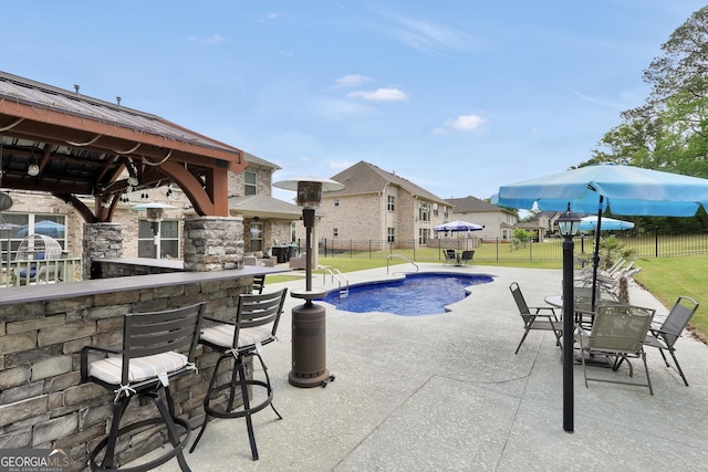 view of swimming pool featuring outdoor dry bar, a gazebo, a fenced backyard, a fenced in pool, and a patio area