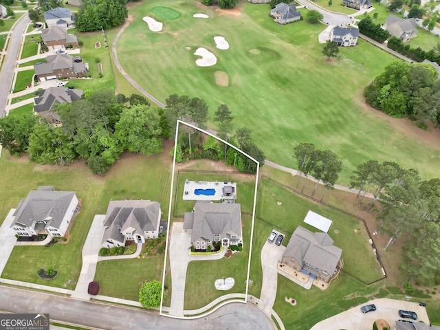 drone / aerial view featuring view of golf course and a residential view