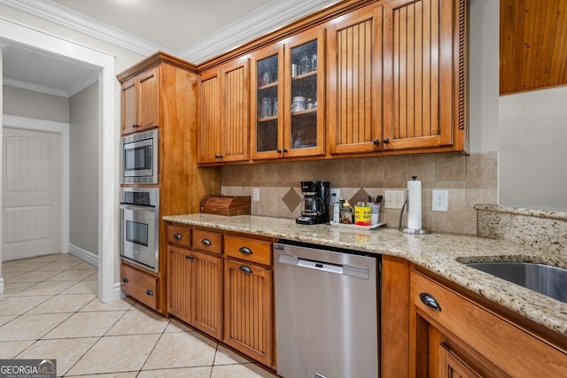 4577 San Saba Dr, Hahira, GA 31632 - kitchen featuring brown cabinets, stainless steel appliances, ornamental molding, and light tile patterned floors