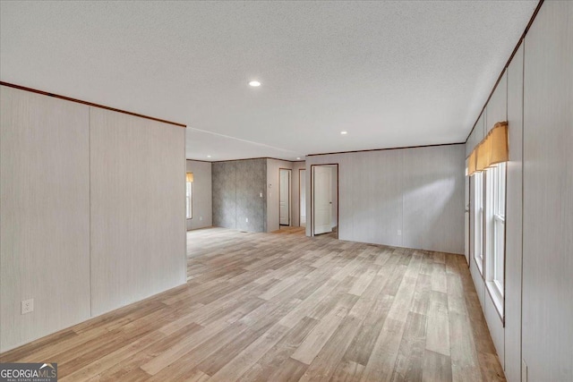 unfurnished living room featuring a textured ceiling, recessed lighting, and light wood-style flooring