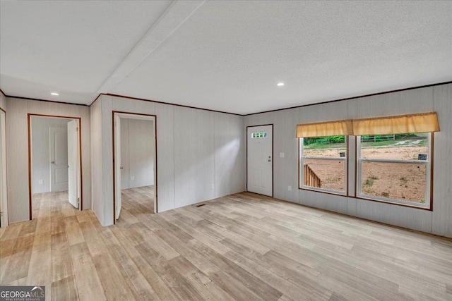 unfurnished room featuring wooden walls, recessed lighting, crown molding, and light wood finished floors