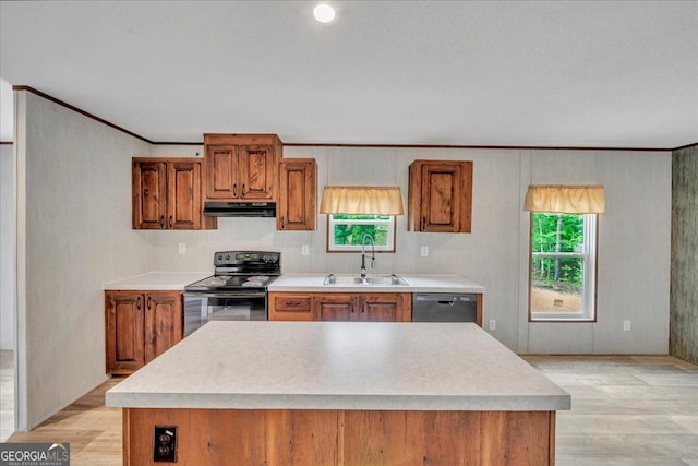 kitchen featuring brown cabinetry, a sink, and black range with electric cooktop