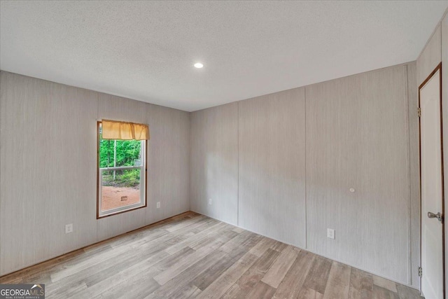 empty room with a textured ceiling and wood finished floors