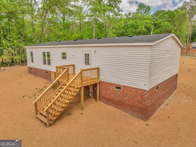 rear view of house featuring stairway, crawl space, and a deck