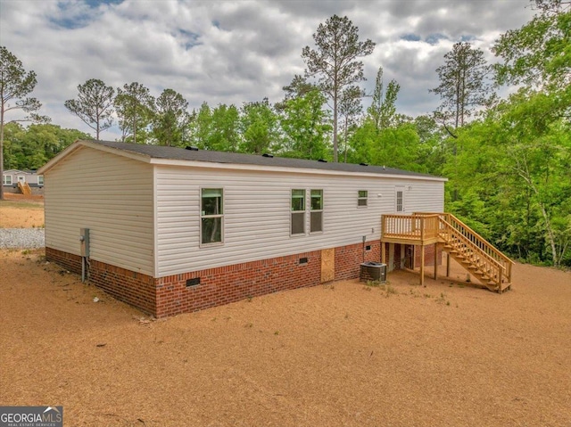 rear view of house featuring a wooden deck, cooling unit, stairway, and crawl space