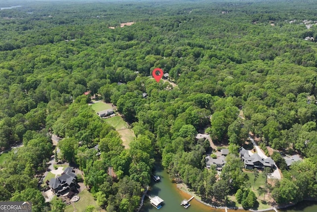 birds eye view of property with a water view and a wooded view