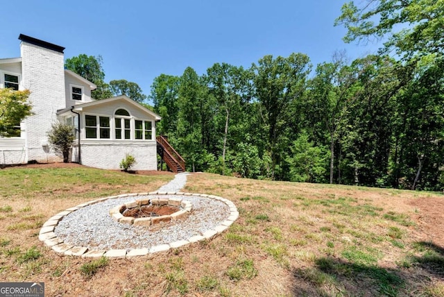 view of yard with a fire pit and stairway