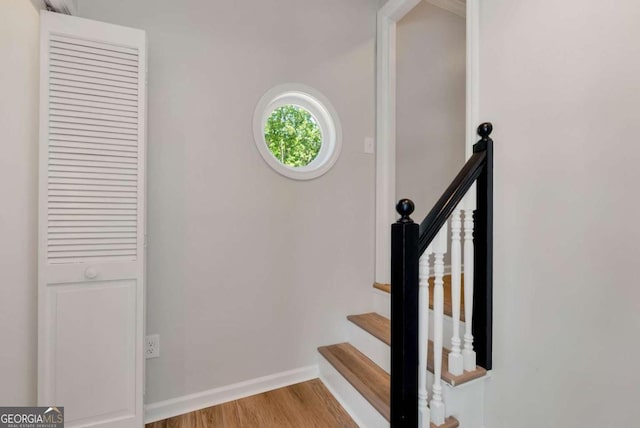 stairway featuring baseboards and wood finished floors