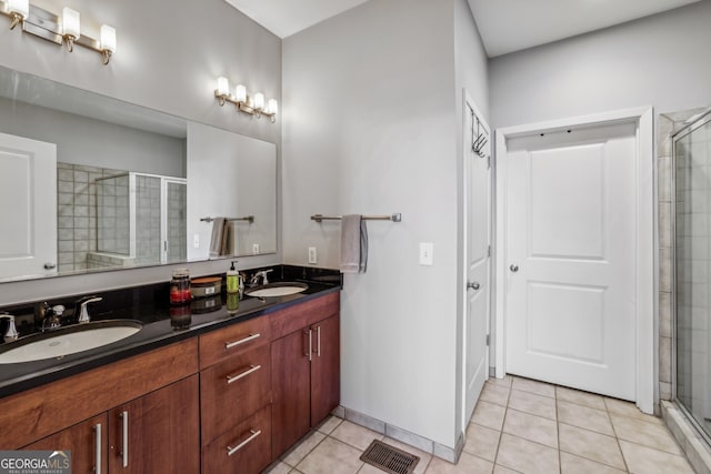 bathroom with tile patterned flooring, a sink, and a stall shower
