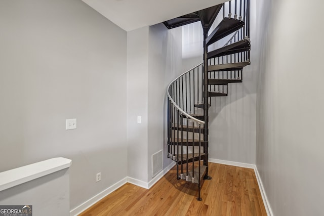 stairs featuring baseboards, visible vents, and wood finished floors