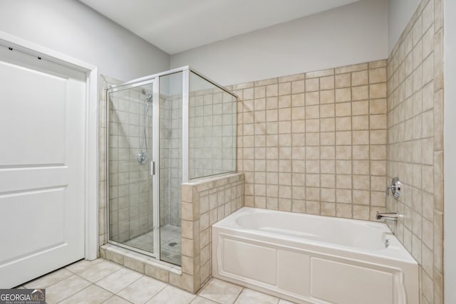 bathroom with tile patterned flooring, a bath, and a shower stall