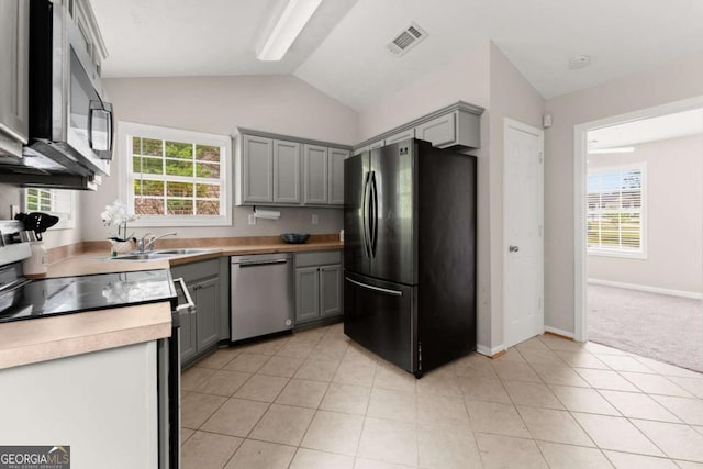 1628 Brook Ln, Monroe, GA 30655 - kitchen with stainless steel appliances, gray cabinets, vaulted ceiling, light tile patterned floors, and light countertops