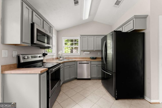 1628 Brook Ln, Monroe, GA 30655 - kitchen featuring stainless steel appliances, gray cabinets, vaulted ceiling, light countertops, and light tile patterned flooring