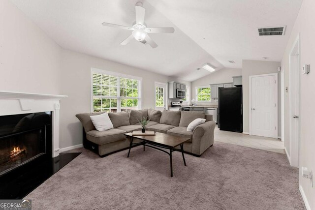 1628 Brook Ln, Monroe, GA 30655 - living room with lofted ceiling, light colored carpet, a ceiling fan, and a fireplace with flush hearth
